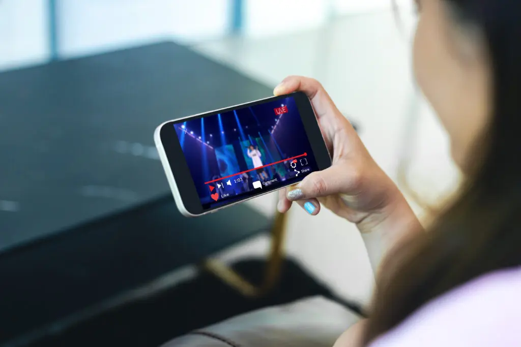 Xfinity Mobile customer in Illinois utilizing new Premium Unlimited plans 4K streaming and hotspot data on WiFi. IMAGE: Female watching a streaming show on her mobile device.