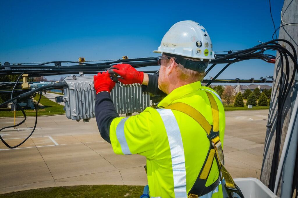 A Comcast technician working on a cable.