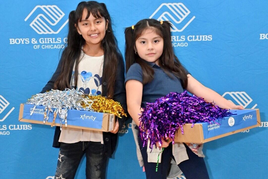 Little Village Boys & Girls Club members holding their new laptops.